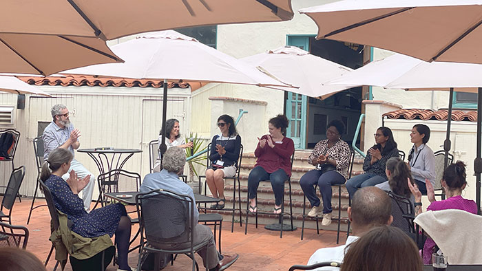 Faculty panelists seated under umbrellas at a MCTEN Workshop, engaging in a discussion with an outdoor audience in attendance at the SDSU Faculty Staff Club.