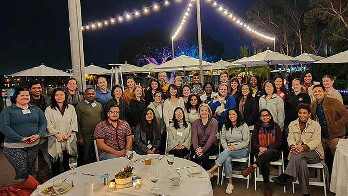 Group photo of attendees at the MCTEN Writing Retreat, gathered outdoors under string lights during an evening event.